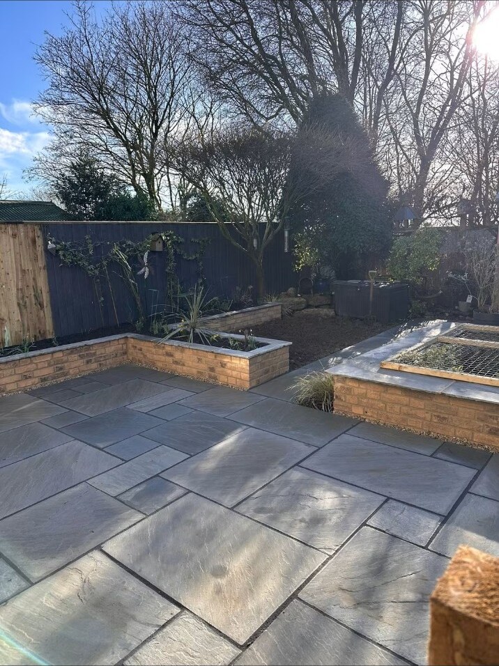 Completed grey natural sandstone patio and garden wall